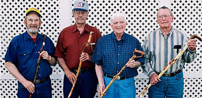 Four men standing together (from left Garold Engel, Gary Teaney, Don Green and Hilary Cole) holding canes upright