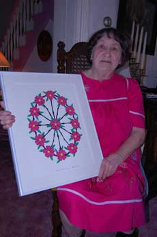 Leona Barthle (woman) with papercutting design (red flowers with green leaves and black stems)