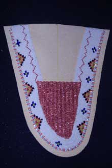 Beadwork pattern (white background with colored beads bordering curve of toe piece) on the toe piece of a moccasin