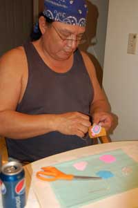 Man (Sherman Bear Ribs) seated worked on beading a turtle.