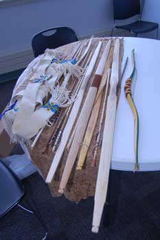 Selection of bows and arrows laid out on a table. Made by Michael He Crow.