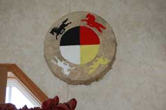 Painted hand drum, painted with circle of the colors of the four directions (yellow, white, black, red). Horses of the same color encircle the four color circle.